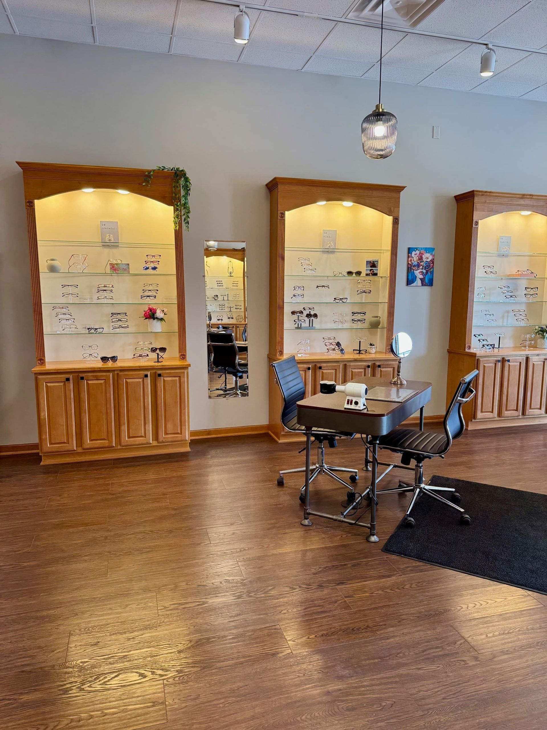 A room with a table , chairs , shelves and a mirror.