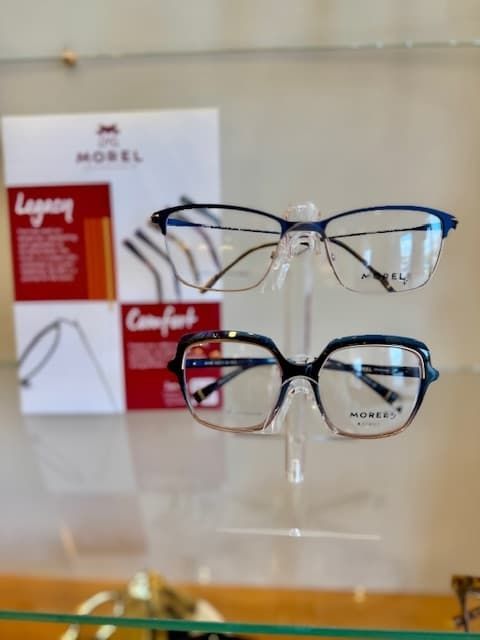 Two pairs of glasses are on display in front of a sign that says comfort