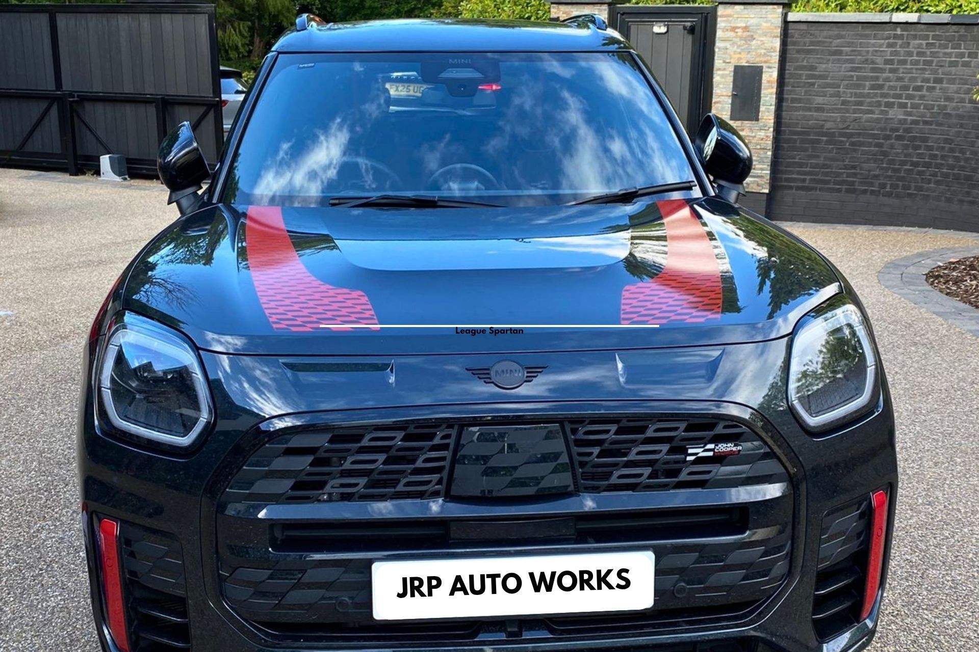 Front view of a black SUV with red hood graphics and JRP Auto Works license plate.