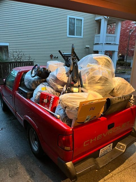 A red chevrolet truck is filled with lots of junk.