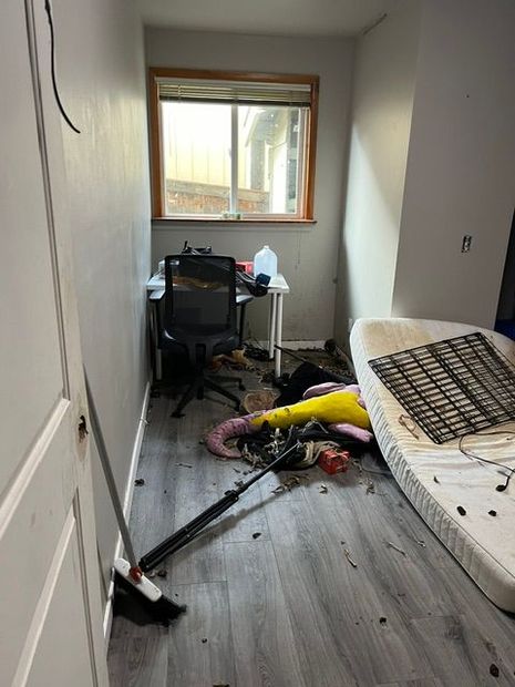 A room with a mattress on the floor and a desk and chair.