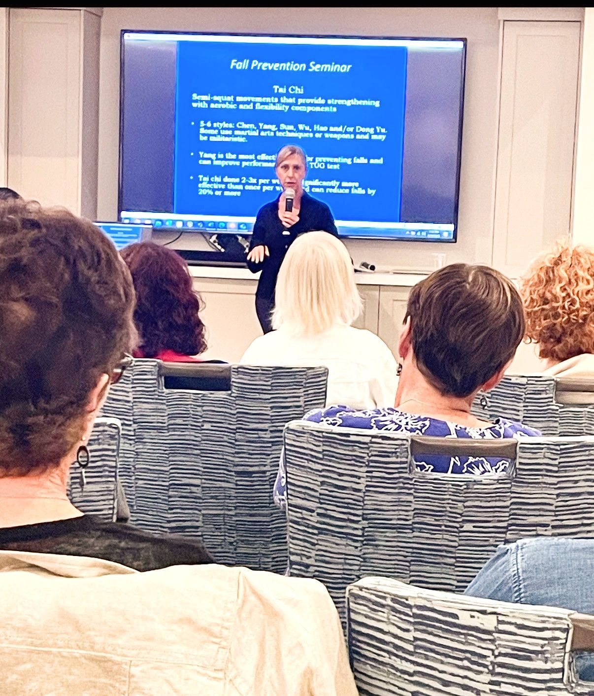 A man is giving a presentation to a group of people sitting around a table.