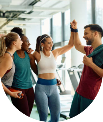 A group of people are looking at a cell phone in a gym.