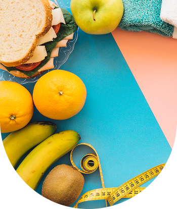 A sandwich , bananas , oranges , apples and a measuring tape on a table.