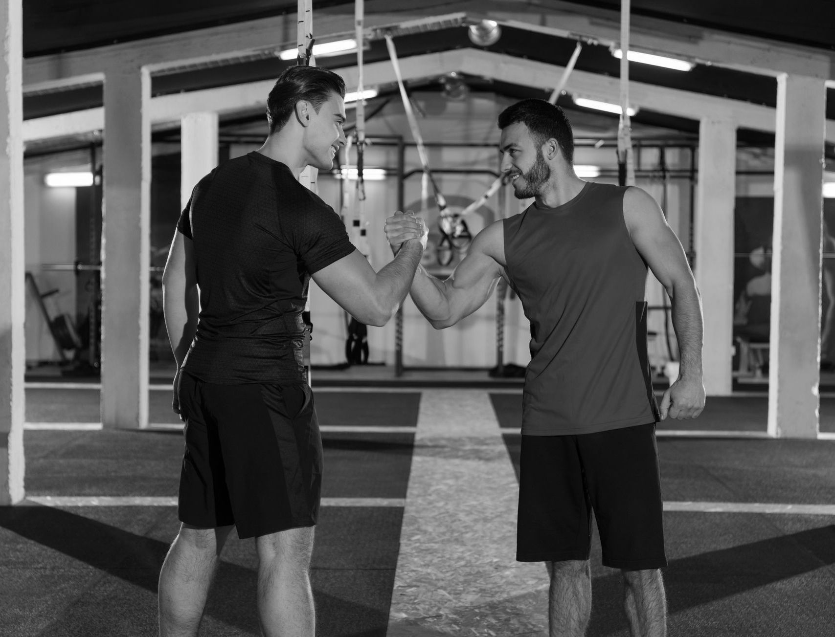 Two men are shaking hands in a gym.