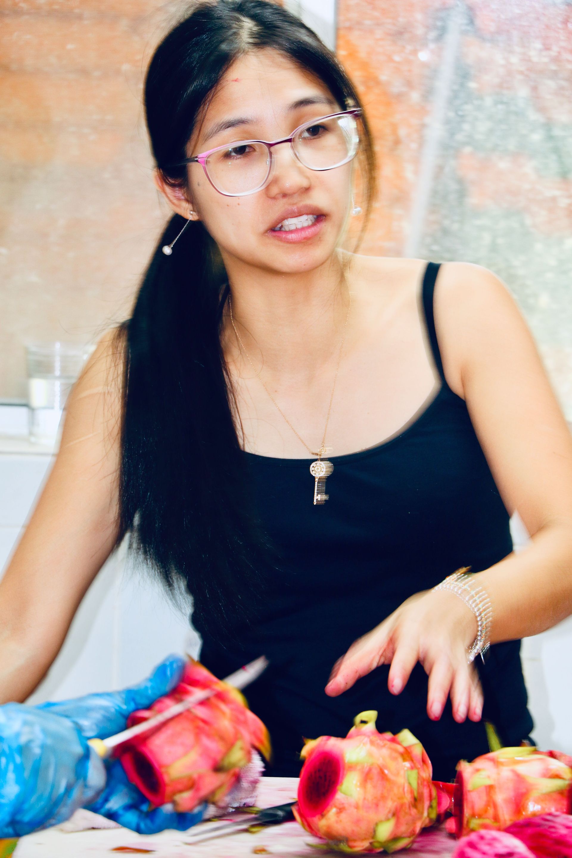 A Woman Wearing Glasses is Cutting a Dragon Fruit — Mareeba Golden Dried Mangoes in Mareeba, QLD
