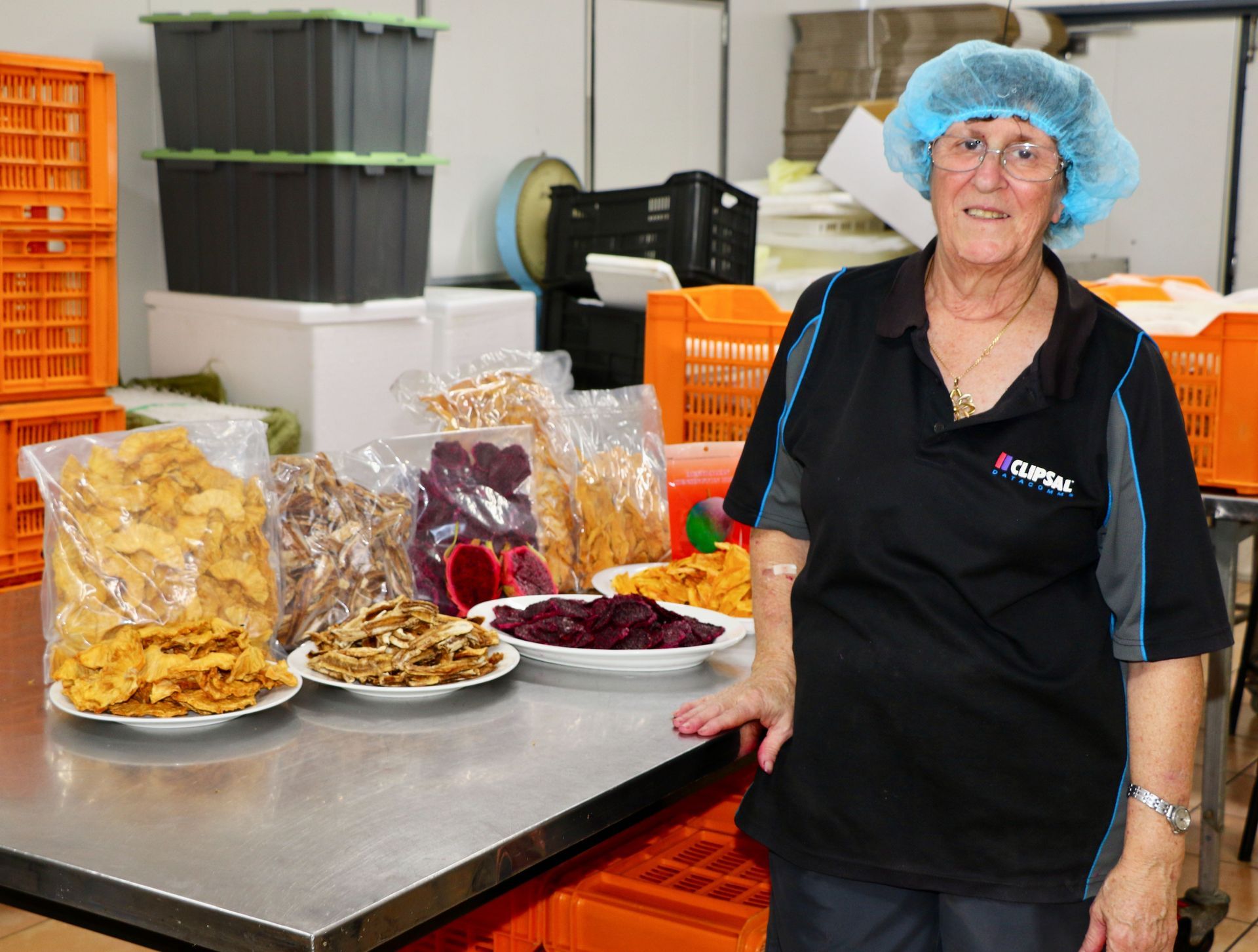 A Woman is Standing in Front of a Table Full of Food — Mareeba Golden Dried Mangoes in Mareeba, QLD