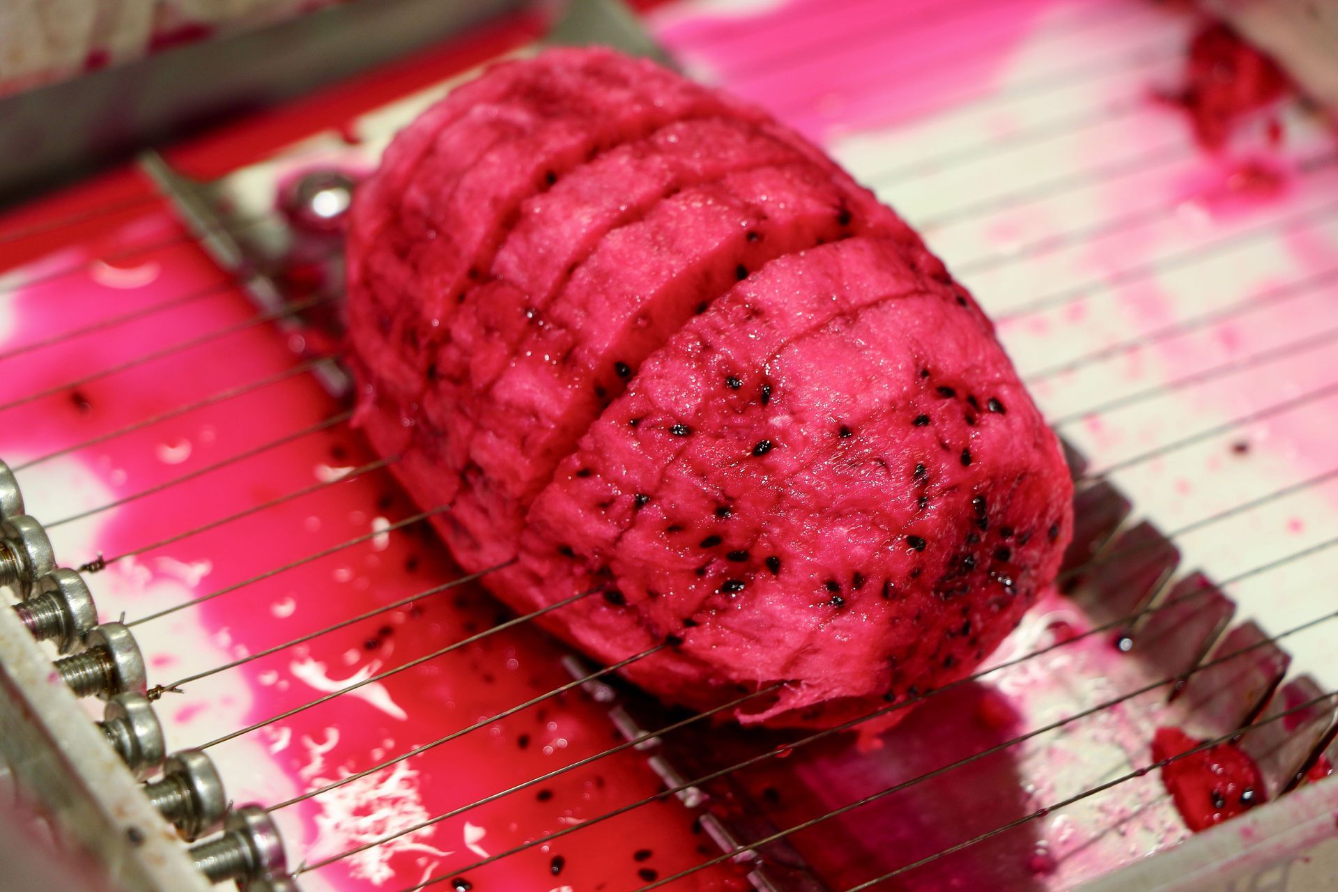 A Dragon Fruit is Being Sliced on a Cutting Machine — Mareeba Golden Dried Mangoes in Mareeba, QLD