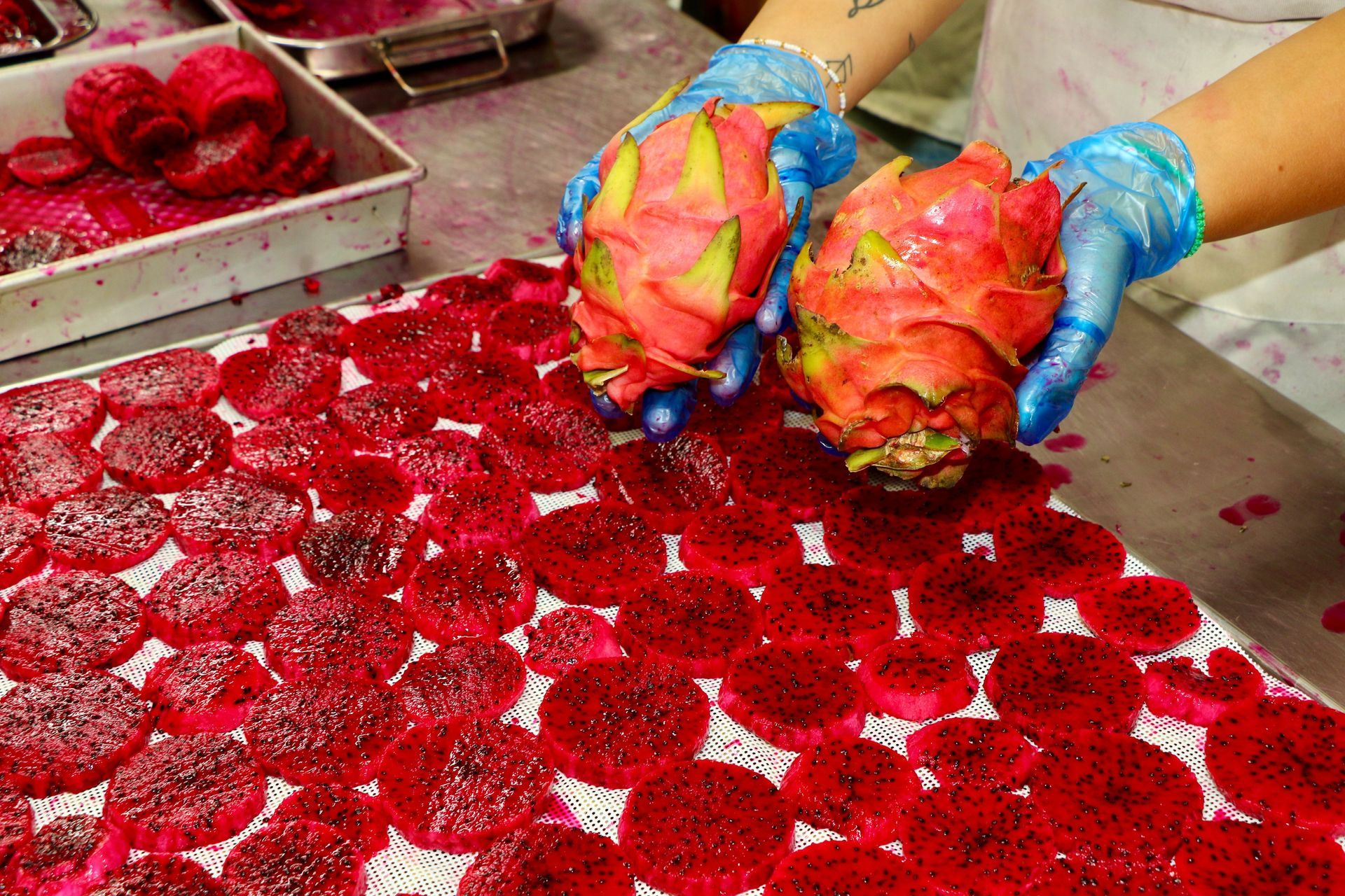 A Woman Wearing a Blue Hat is Standing in Front of a Rack of Food — Mareeba Golden Dried Mangoes in Mareeba, QLD