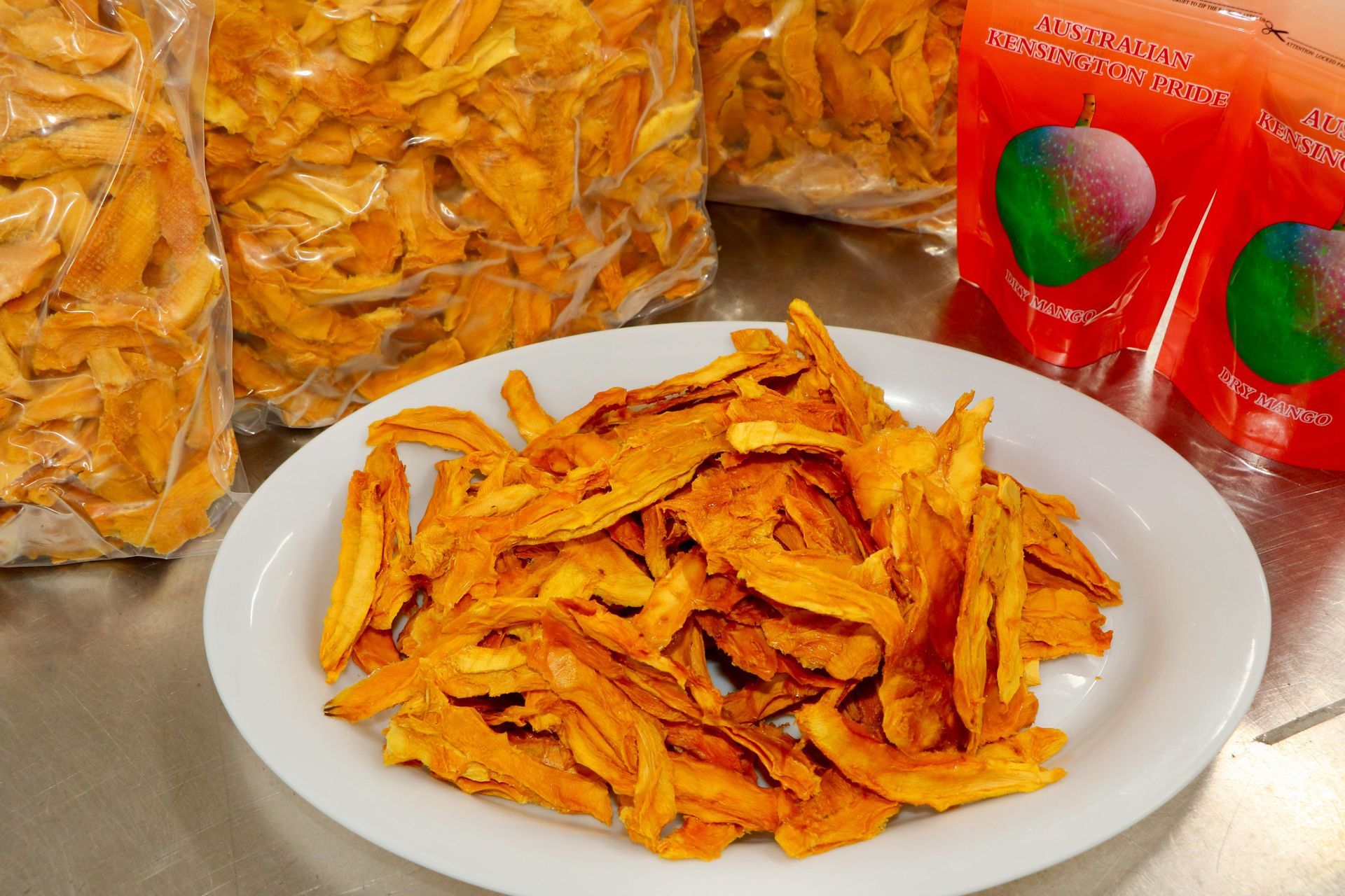 A Group of People Are Working on A Conveyor Belt in A Kitchen — Mareeba Golden Dried Mangoes in Mareeba, QLD