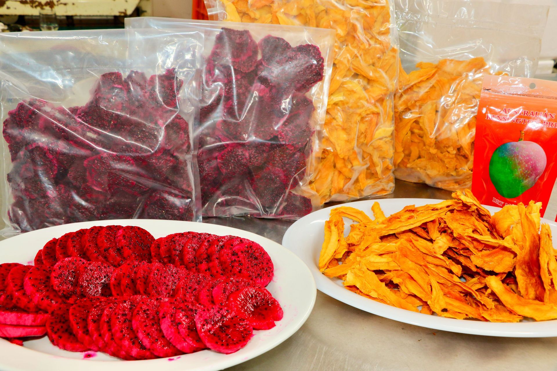 A Table Topped With Plates of Food and Bags of Food — Mareeba Golden Dried Mangoes in Mareeba, QLD