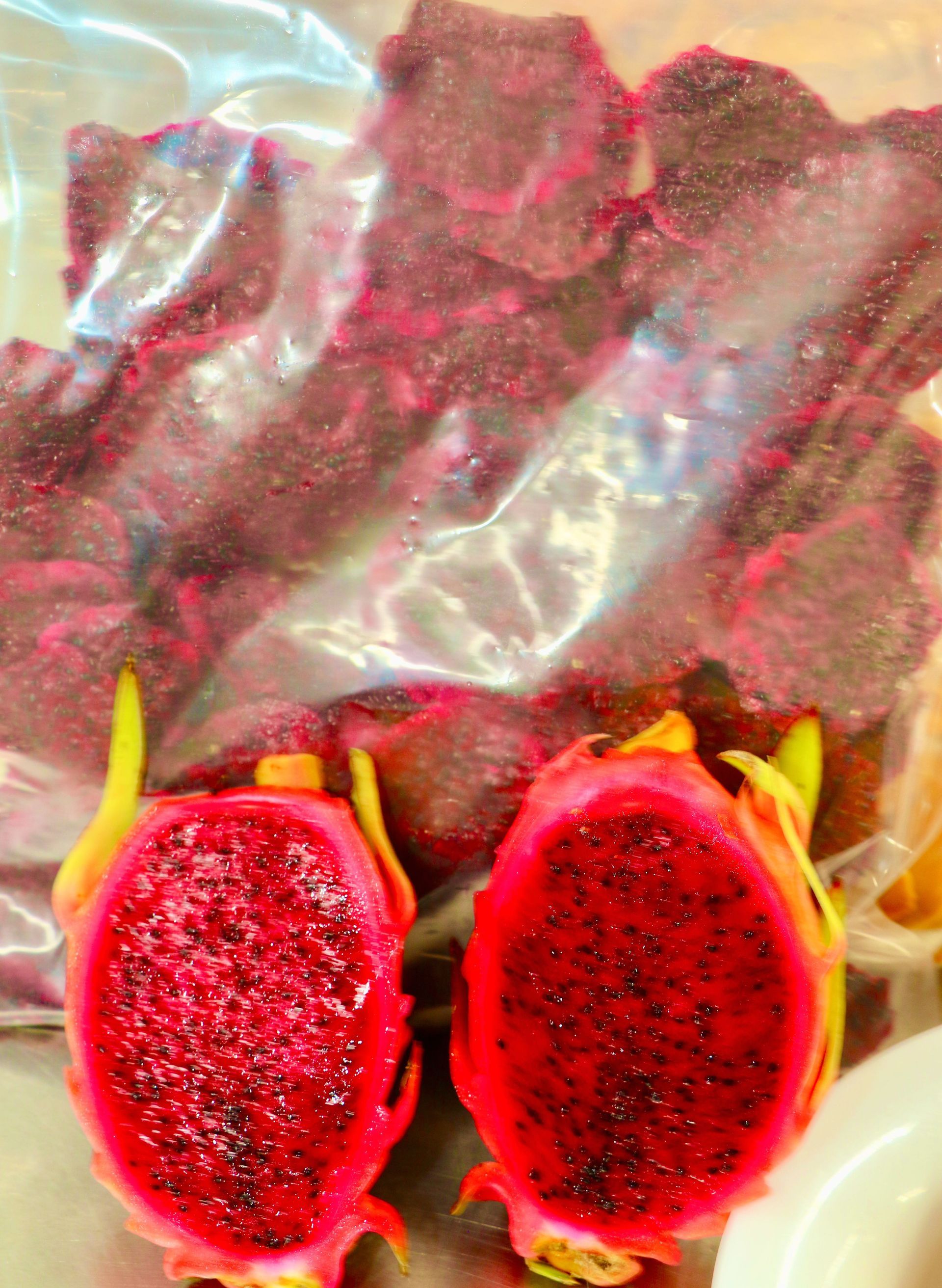 Two Dragon Fruits Cut in Half Next to a Bag of Dragon Fruit — Mareeba Golden Dried Mangoes in Mareeba, QLD