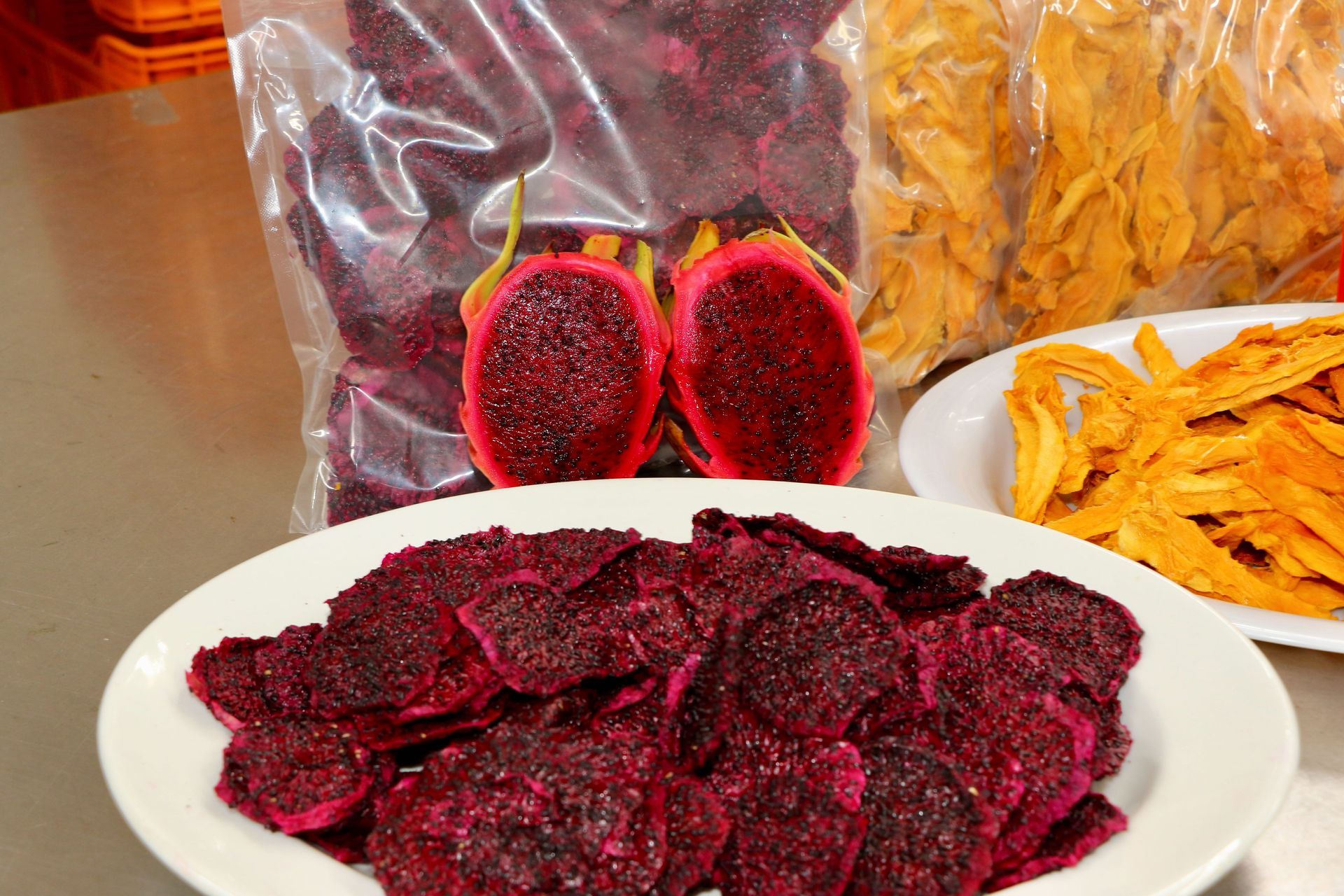A White Plate Topped With Purple Chips Next to a Bag of Dried Fruit — Mareeba Golden Dried Mangoes in Mareeba, QLD