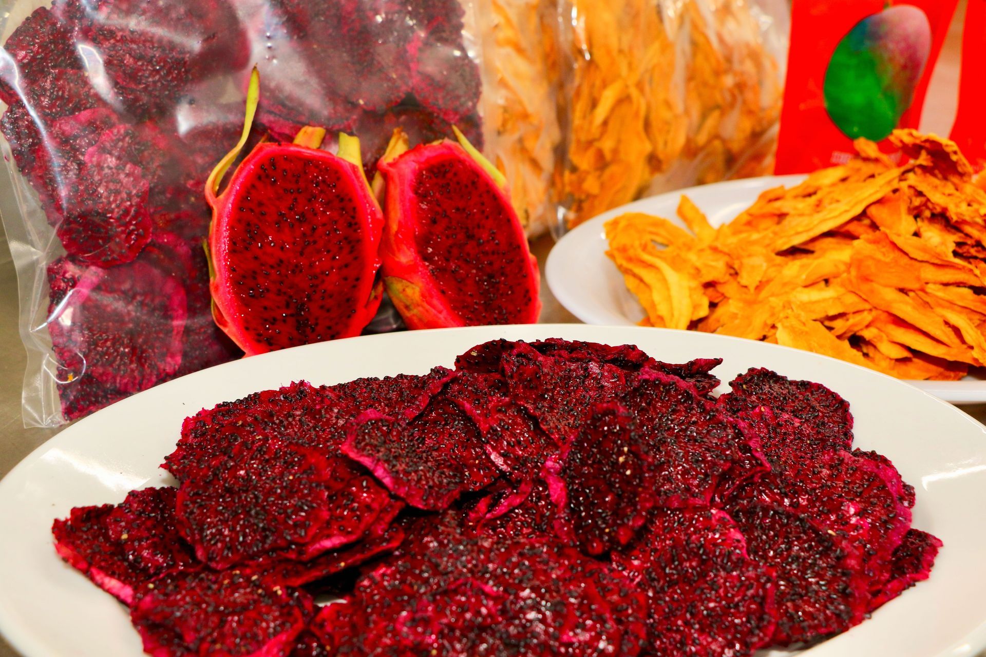 A Plate of Dragon Fruit Chips Next to a Bag of Dragon Fruit Chips — Mareeba Golden Dried Mangoes in Mareeba, QLD