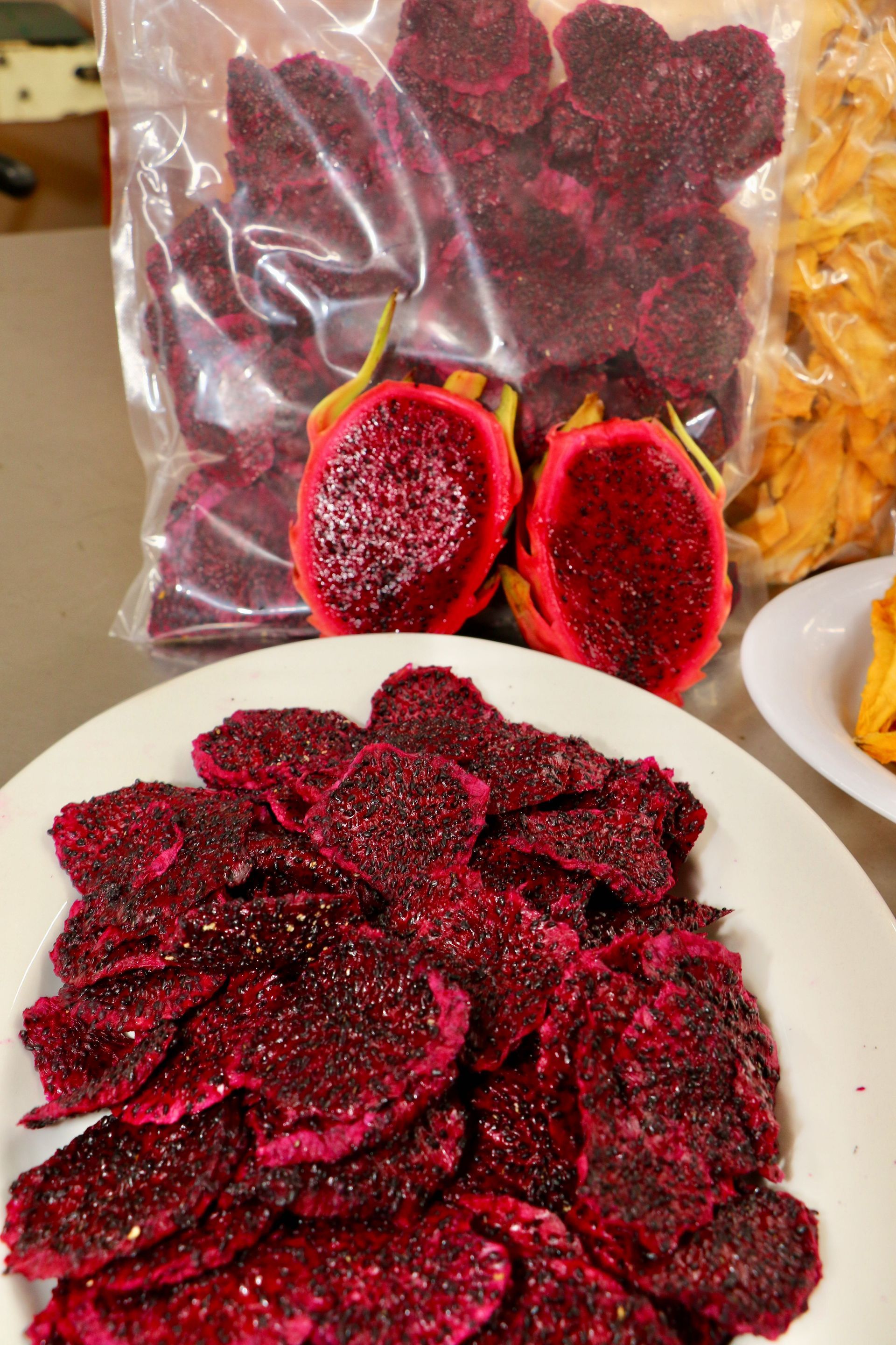 A Plate of Dried Dragon Fruit Next to a Bag of Dried Dragon Fruit — Mareeba Golden Dried Mangoes in Mareeba, QLD