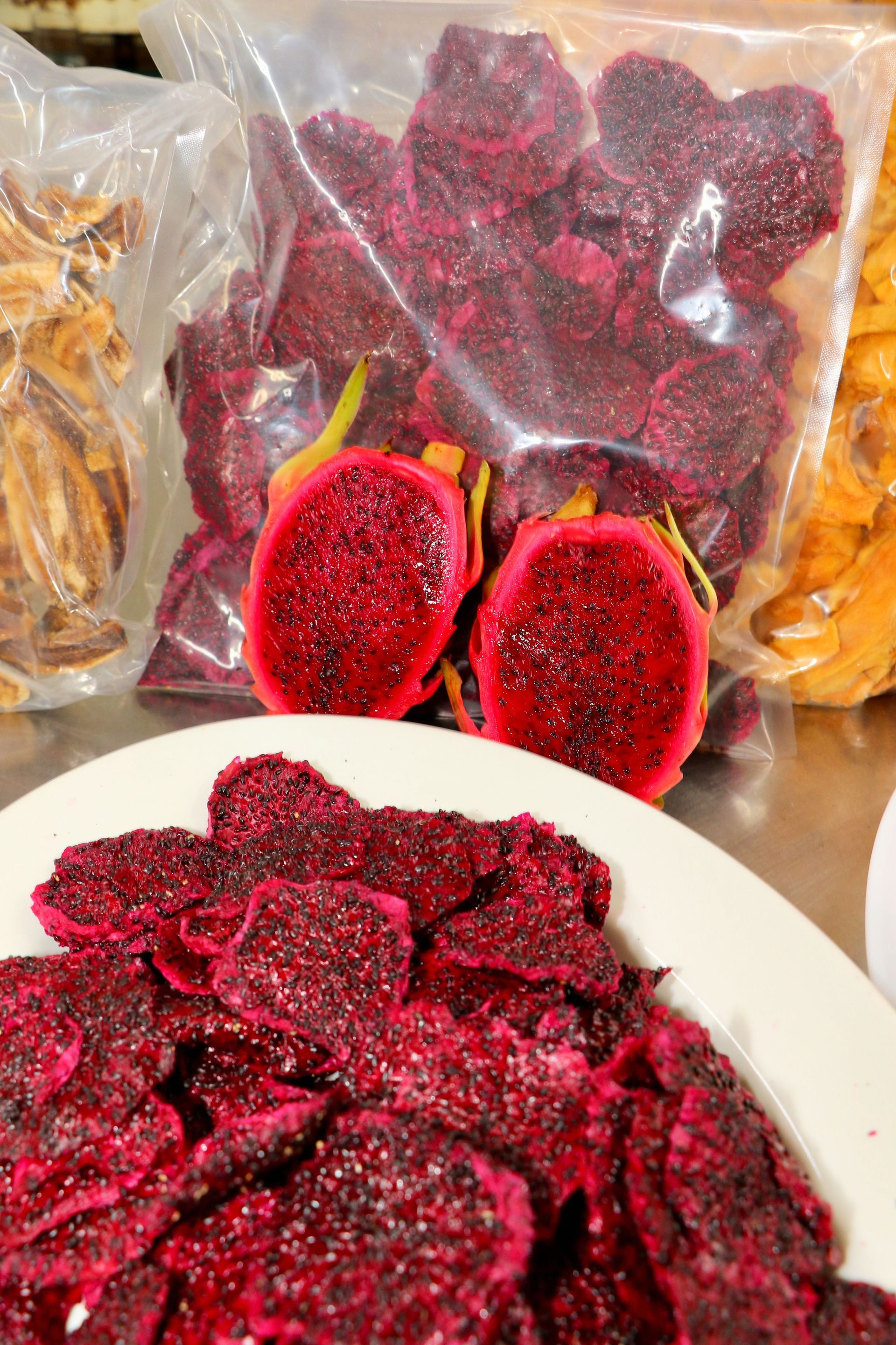 A Person Wearing Black Gloves is Holding a Piece of Red Fruit — Mareeba Golden Dried Mangoes in Mareeba, QLD