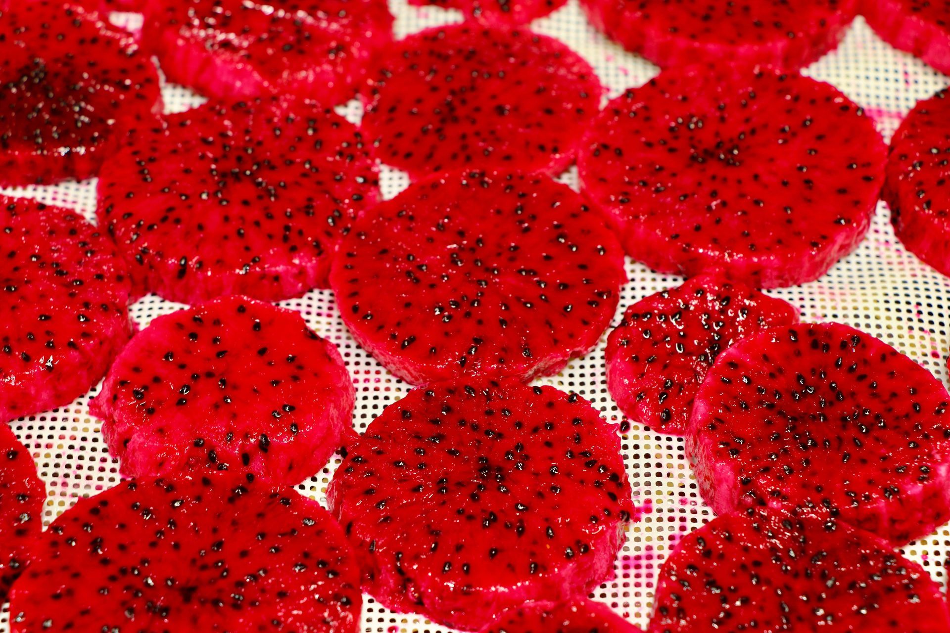 A bunch of red slices of dragon fruit are sitting on a table.