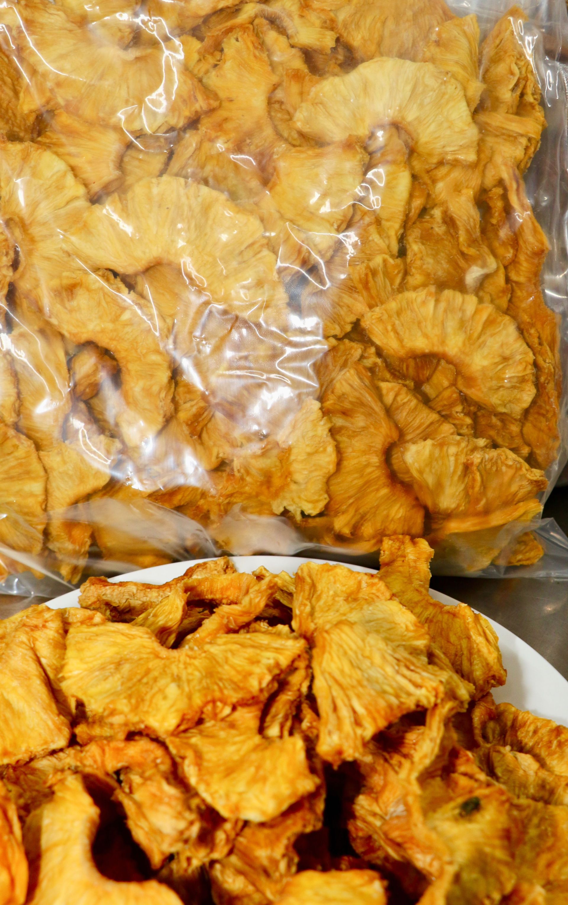 A Person Wearing Black Gloves is Holding a Red Fruit — Mareeba Golden Dried Mangoes in Mareeba, QLD