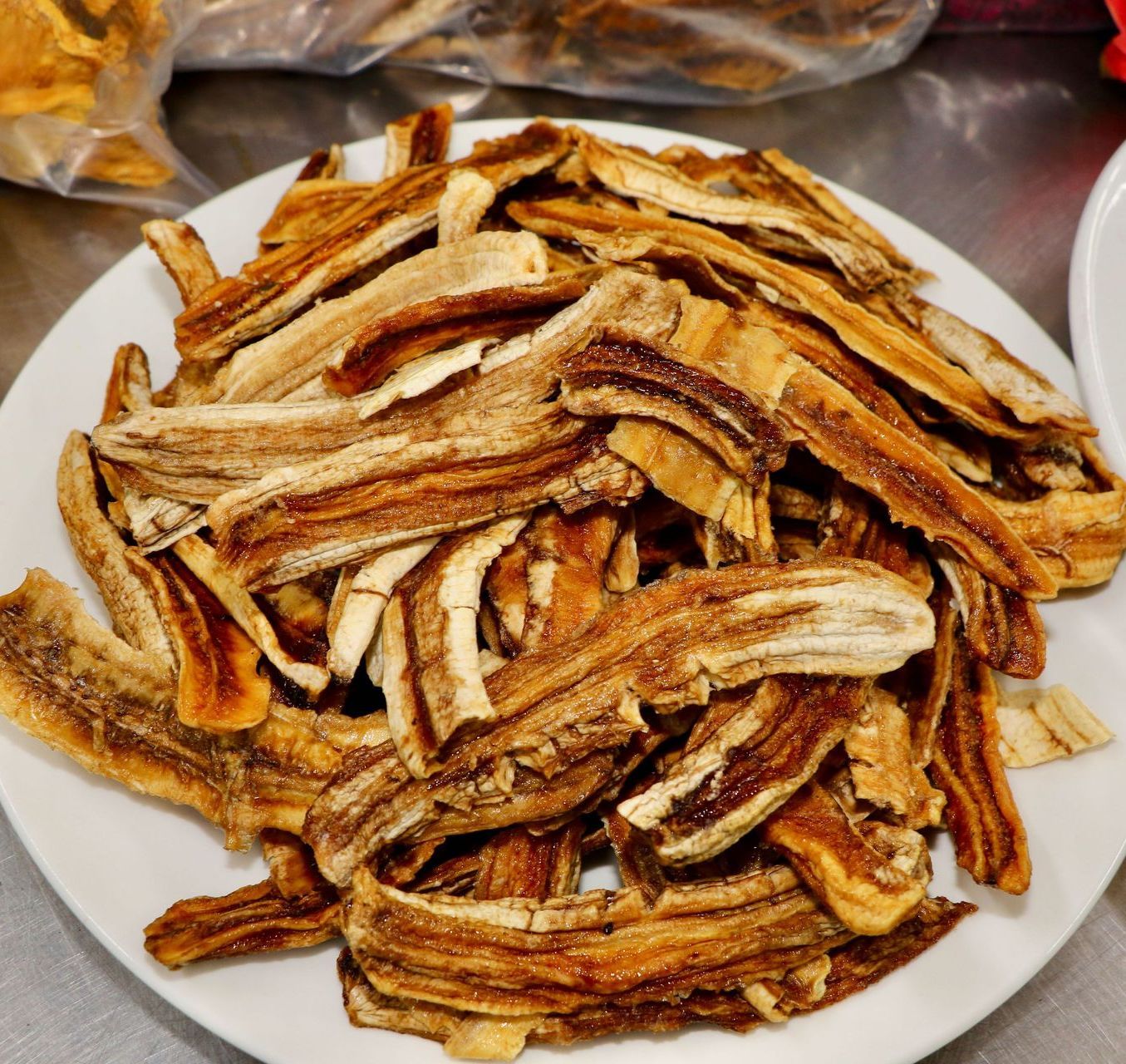 A Bunch of Dried Bananas Cut on A White Plate — Mareeba Golden Dried Mangoes in Mareeba, QLD
