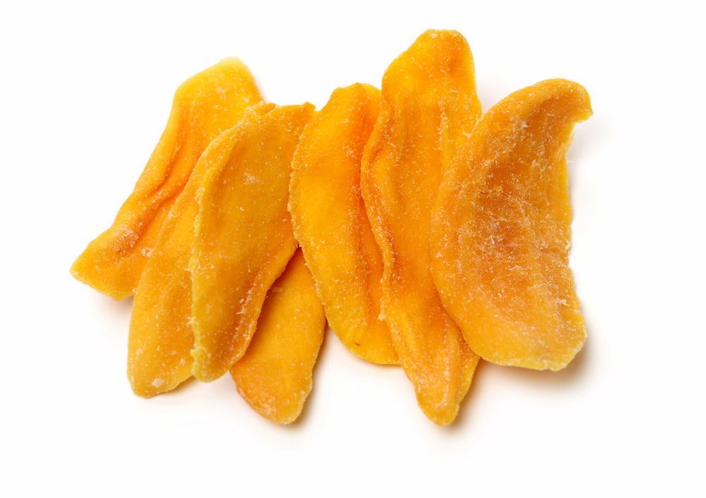 A Pile of Dried Mango Slices on a White Background — Mareeba Golden Dried Mangoes in Cairns, QLD