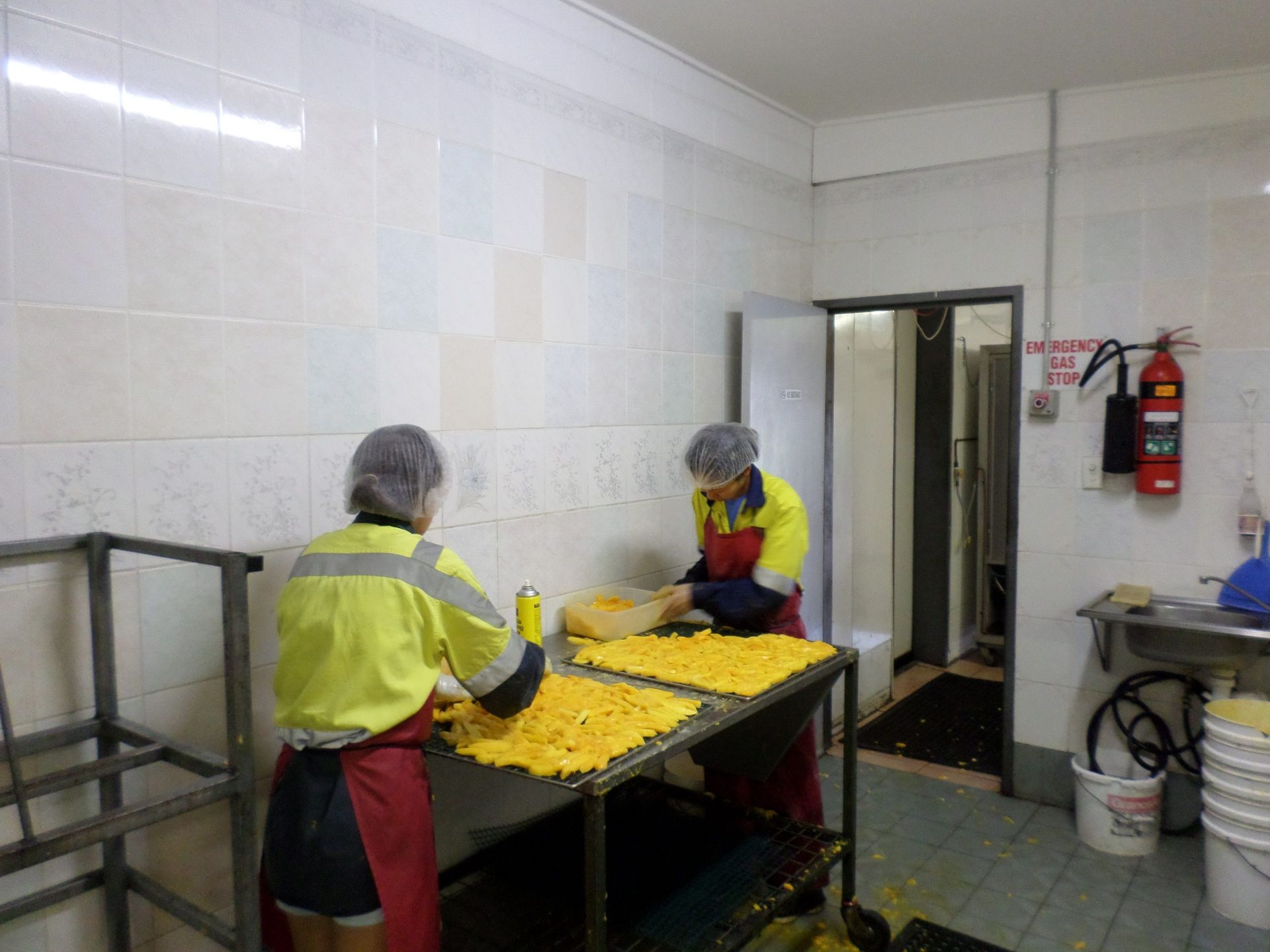 Two People Are Working on a Table in a Kitchen — Mareeba Golden Dried Mangoes in Mareeba, QLD
