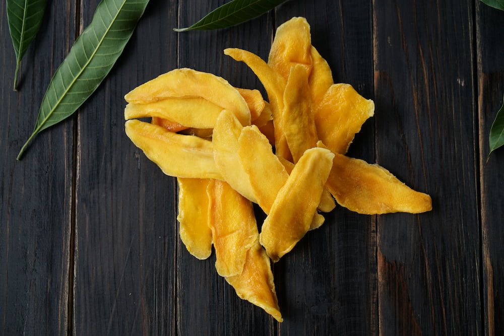 A Pile of Dried Mango Slices on a Wooden Table — Mareeba Golden Dried Mangoes in Gold Coast, QLD