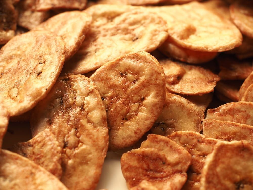 A Pile of Fried Banana Chips on a White Plate — Mareeba Golden Dried Mangoes in Gold Coast, QLD