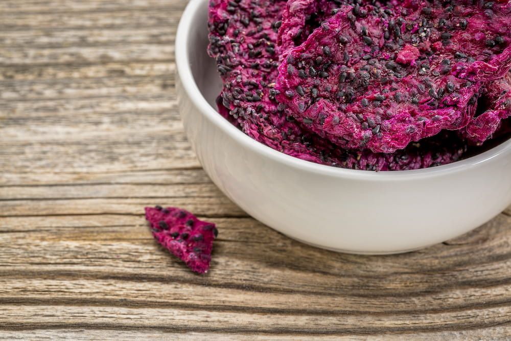 A Bowl of Dried Dragon Fruit Chips on a Wooden Table — Mareeba Golden Dried Mangoes in Cairns, QLD