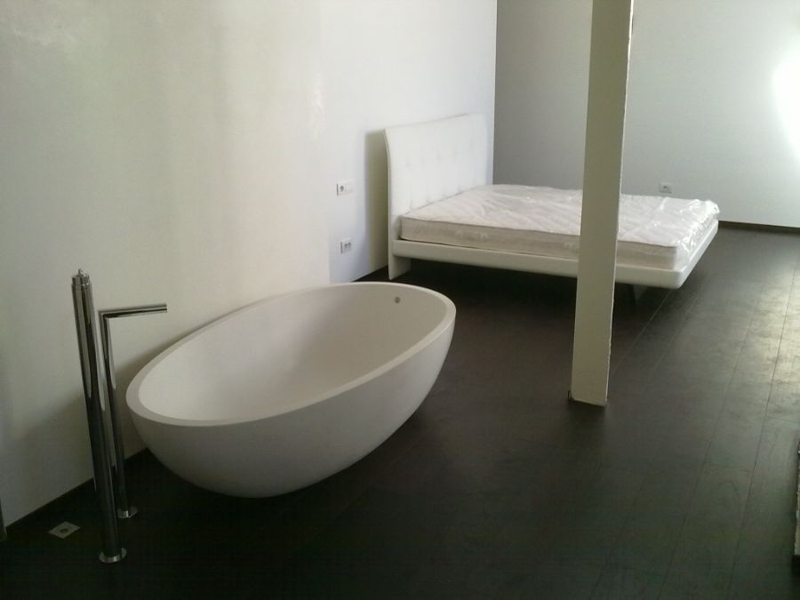 Una vasca da bagno in un bagno accanto a un letto