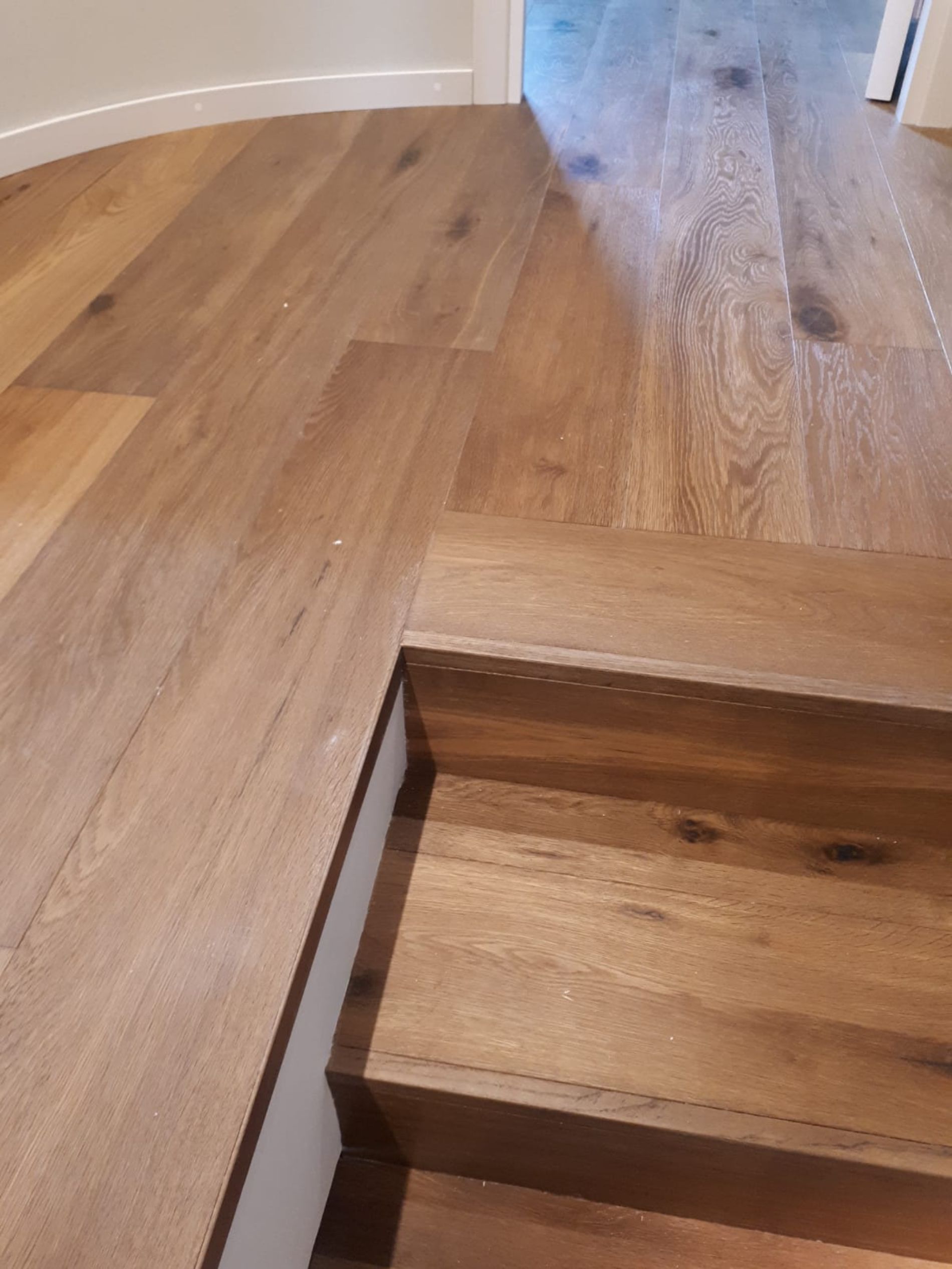 Primo piano del pavimento in legno e delle scale in una stanza.