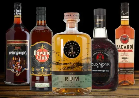 A group of rum bottles are sitting on a wooden table.