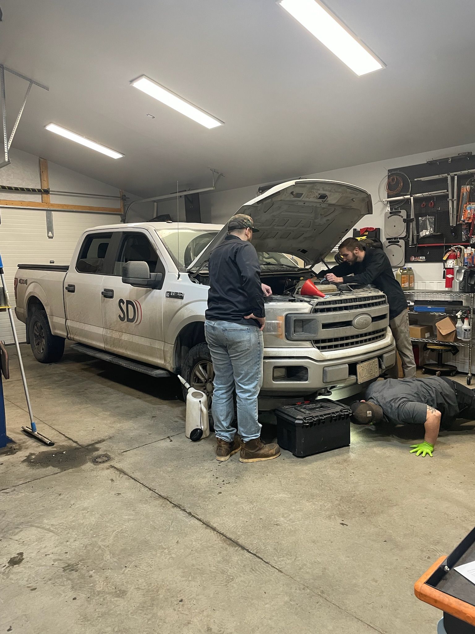 Two Mechanics Working On White Pickup Truck With Hood Open In Auto Shop | Hatch Peak Motorworks