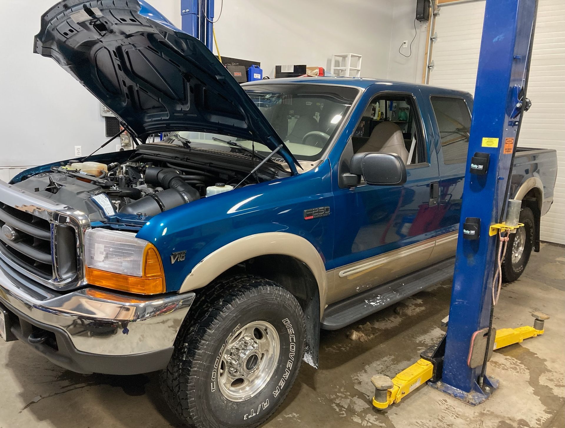 Blue Ford Truck With Hood Open On Vehicle Lift Inside Garage | Hatch Peak Motorworks