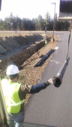 A Worker Holding a Pipe — Paving Services in Nashua, NH