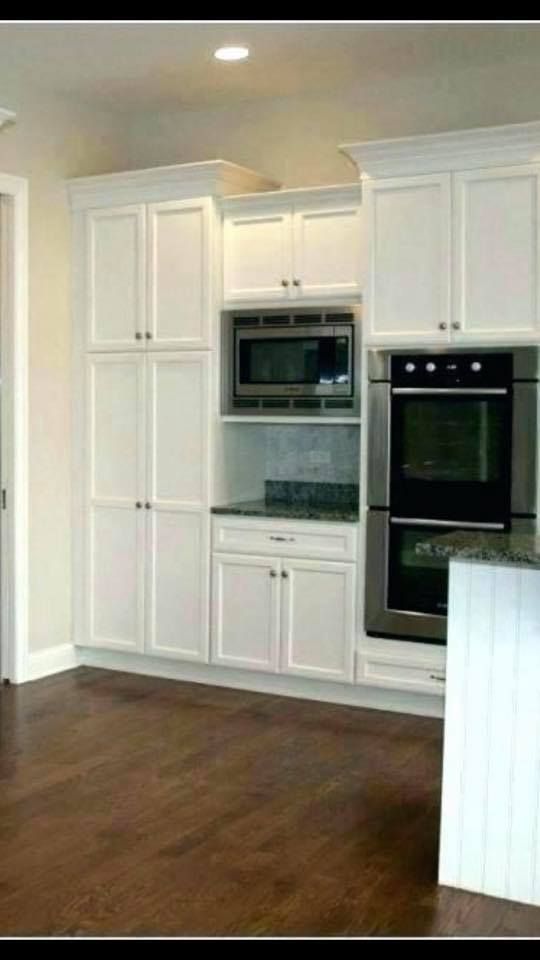 Construction inside a pool area. Two workers on scaffolding are working on the ceiling. Pool is covered in blue plastic.