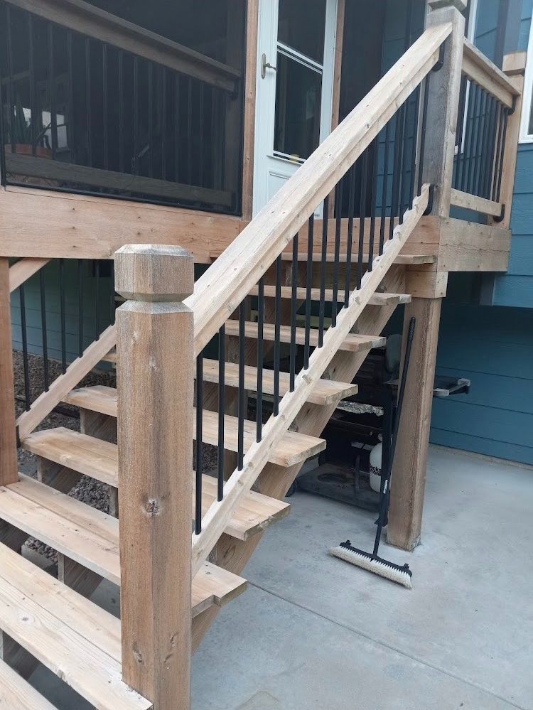 A wooden staircase leading up to a screened in porch.