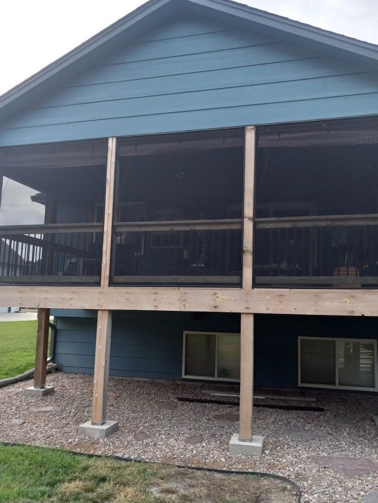 A blue house with a large screened in porch
