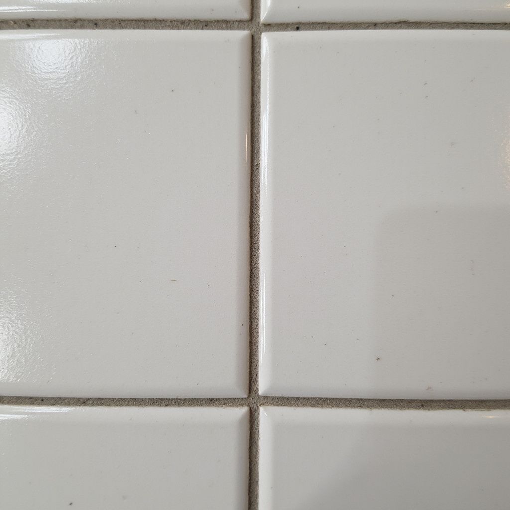 White ceramic tiles with gray grout.