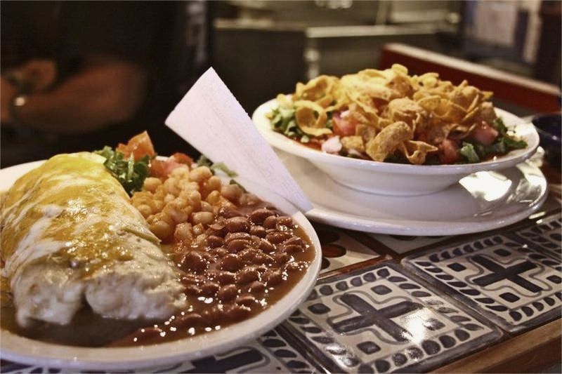 Delicious looking New Mexican food in the food window of  restaurant.