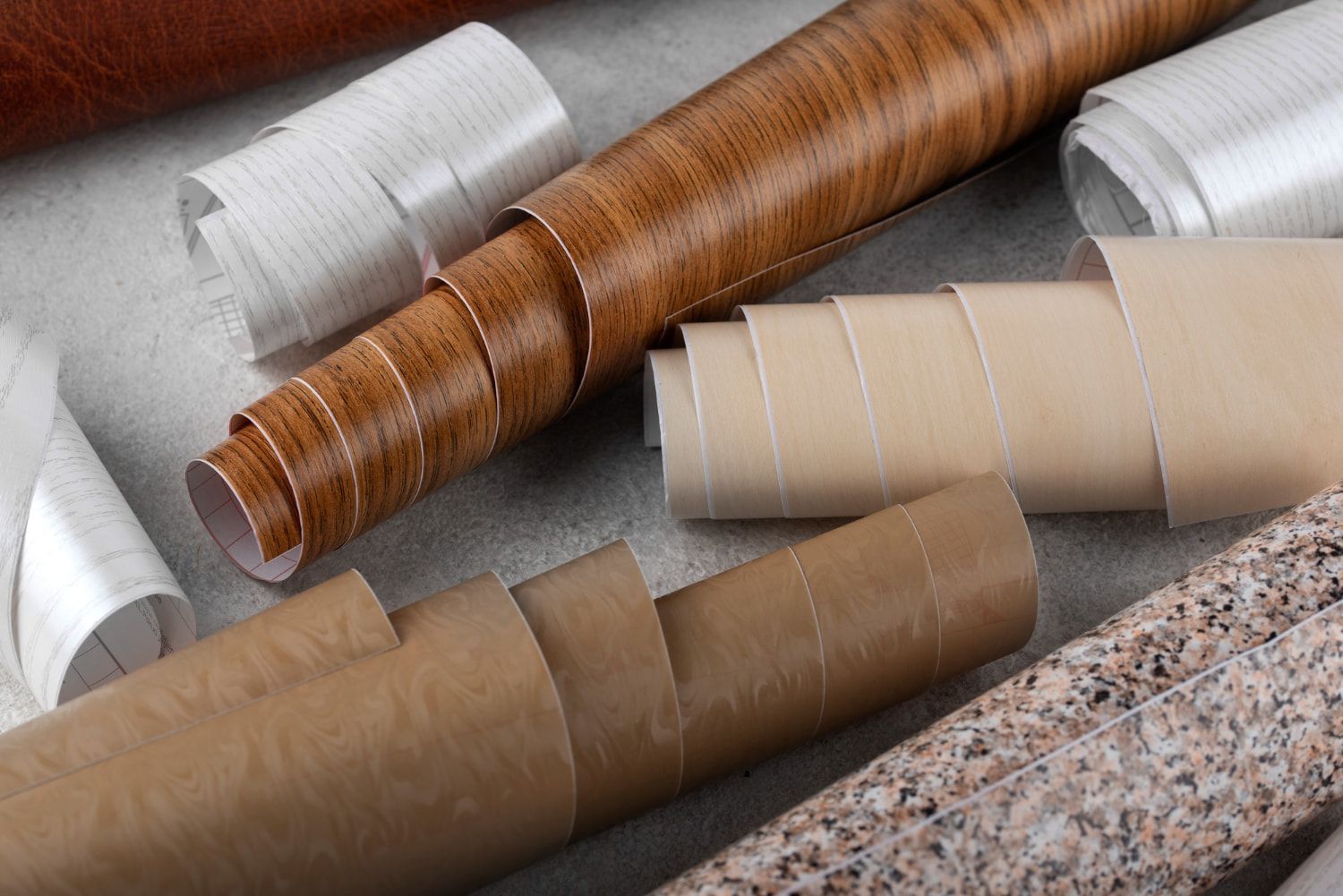 A bunch of rolls of wallpaper are sitting on top of each other on a table.