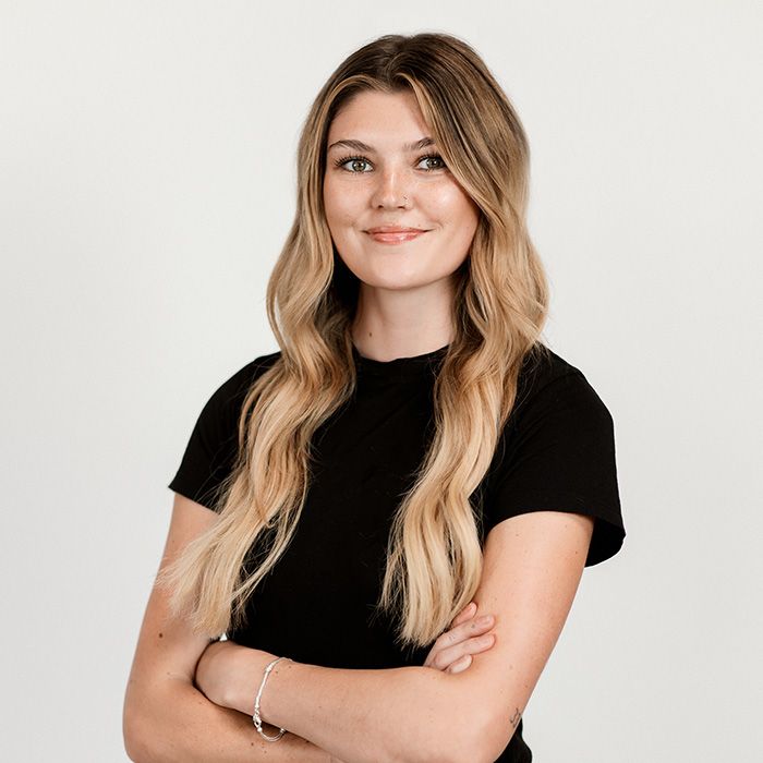 The woman is wearing a black shirt and has her arms crossed.