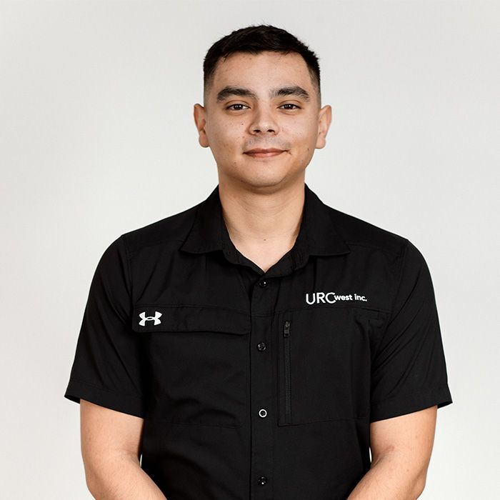 Man in black collared shirt smiling, with