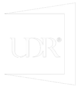 White UDR logo with a registered trademark symbol on a faint geometric background