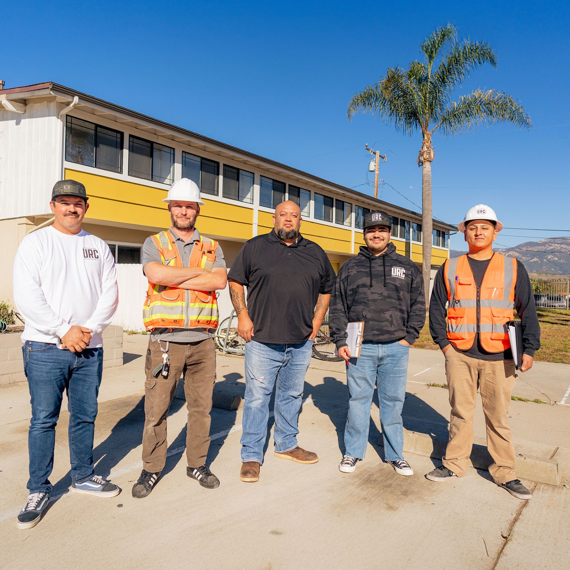A man and a woman are standing next to each other looking at a piece of paper.