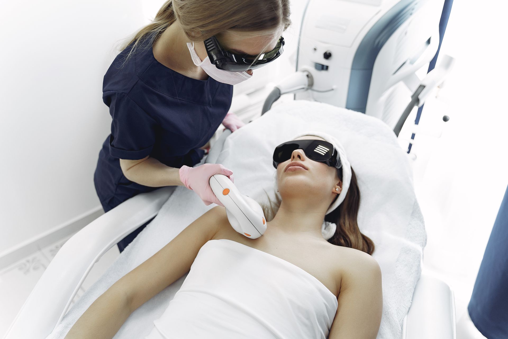 A woman is getting a laser hair removal treatment on her chest.