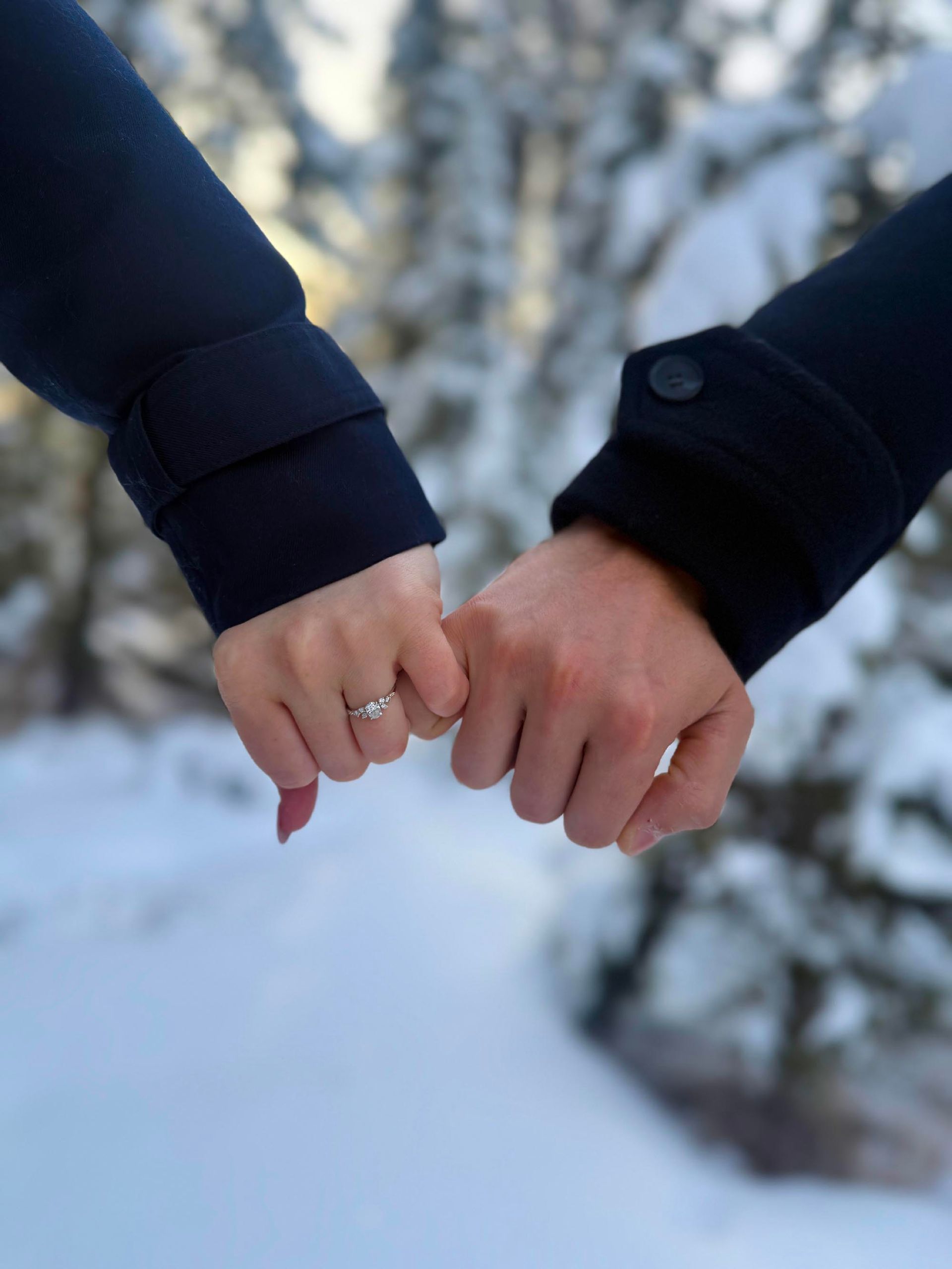Travis and Emma holding hands with engagement ring