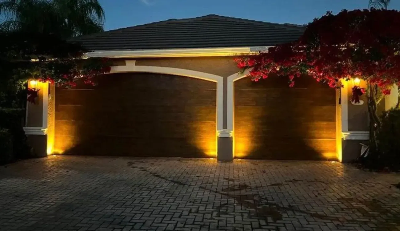 A couple of garage doors are lit up at night.