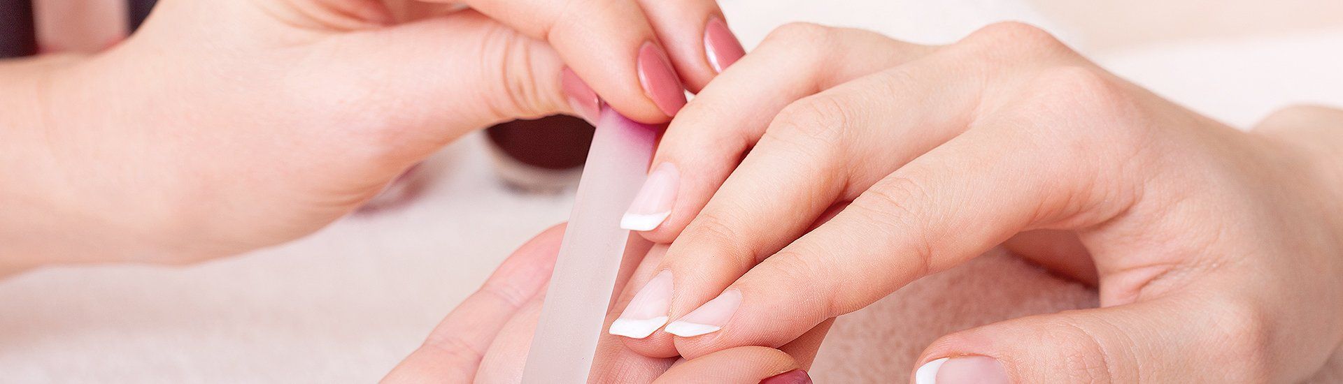 nails being filed prior to manicure session