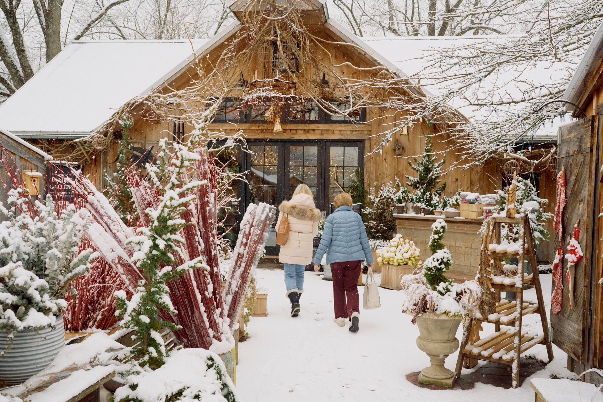 A skincare product on a tray with a flower, towels, and a bathtub in a warm-toned bathroom.