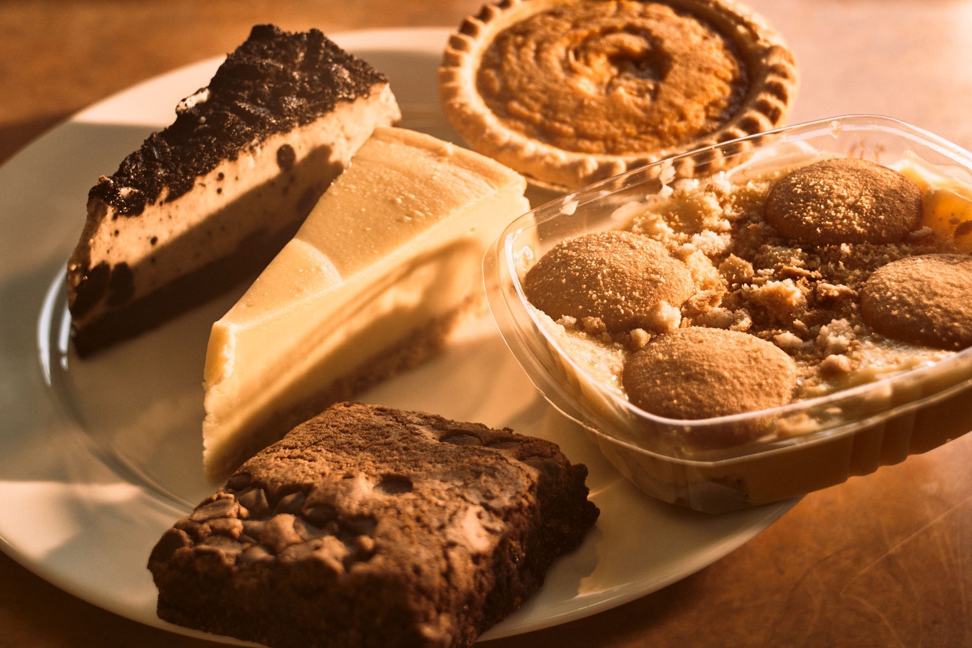 A white plate topped with a variety of desserts including brownies and pies